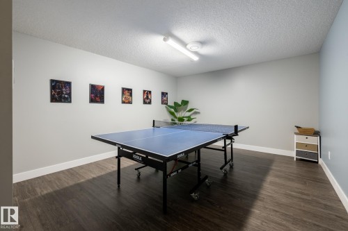 Recreation room in the basement featuring wood-finish flooring, light gray walls, and bright overhead lighting - 1440 Darby Green, Edmonton, AB - Indoor Photo Showing Other Room