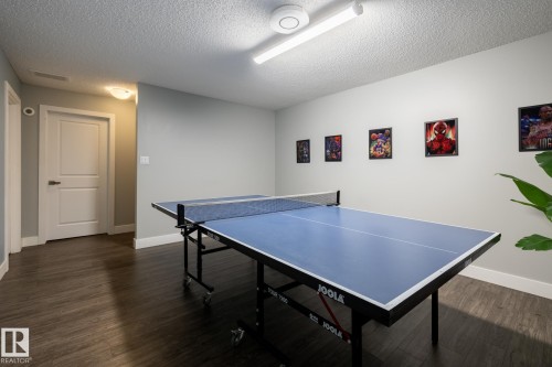 Recreation room in the basement featuring wood-finish flooring, light gray walls, and bright overhead lighting - 1440 Darby Green, Edmonton, AB - Indoor Photo Showing Other Room