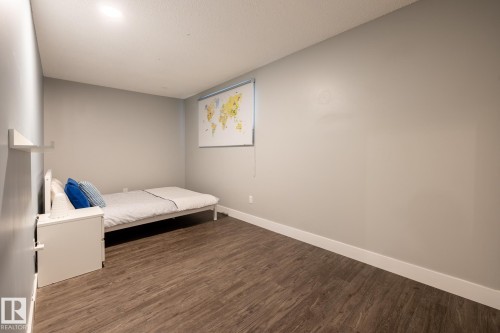 Spacious room featuring wood-finish flooring, light gray wall paint, and white baseboards - 1440 Darby Green, Edmonton, AB - Indoor