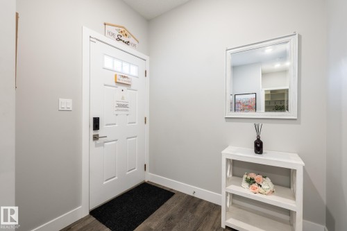 Entryway featuring a paneled door with glass inserts, wood-finish flooring, and light gray walls - 1440 Darby Green, Edmonton, AB - Indoor Photo Showing Other Room