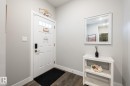 Entryway featuring a paneled door with glass inserts, wood-finish flooring, and light gray walls - 1440 Darby Green, Edmonton, AB  - Indoor Photo Showing Other Room 