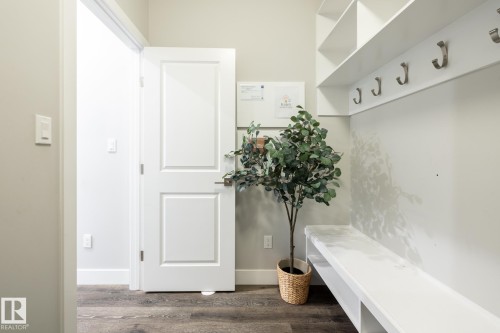 Entryway featuring wood-finish flooring, white paneled doors, and light gray walls - 1440 Darby Green, Edmonton, AB - Indoor Photo Showing Other Room