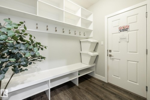 Entryway mudroom featuring white built-in shelving, coat hooks, and a bench with integrated storage cubbies - 1440 Darby Green, Edmonton, AB - Indoor
