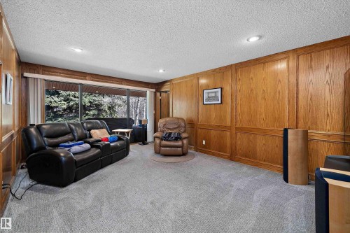 Spacious room featuring extensive wood paneling, recessed lighting, wall-to-wall carpeting, and floor-to-ceiling windows with outdoor scenery - 227 Westridge Road, Edmonton, AB - Indoor