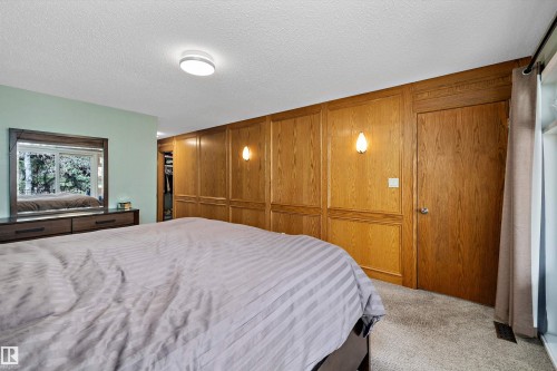 Wood paneled accent wall with integrated sconce lighting - 227 Westridge Road, Edmonton, AB - Indoor Photo Showing Bedroom