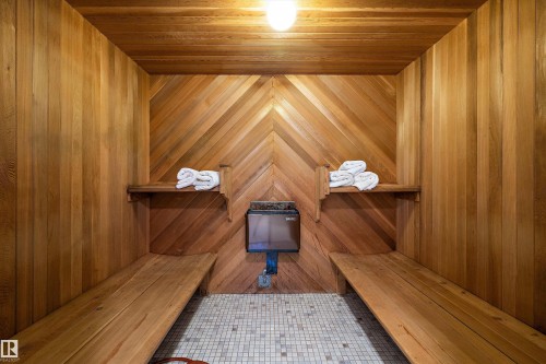 Dedicated sauna featuring warm wood paneling, built-in benches, a wall-mounted heater, and small square tile flooring - 227 Westridge Road, Edmonton, AB - Indoor Photo Showing Other Room