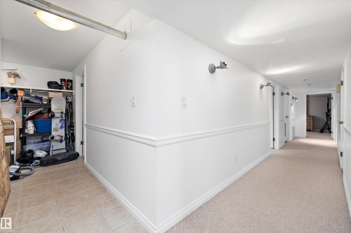 Hallway featuring wainscoting, recessed lighting, and wall-mounted sconces - 227 Westridge Road, Edmonton, AB - Indoor