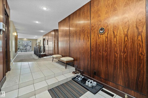 Entryway featuring wood paneling, tiled flooring, recessed lighting, and a partial view of a carpeted hallway with a railing - 227 Westridge Road, Edmonton, AB - Indoor Photo Showing Other Room