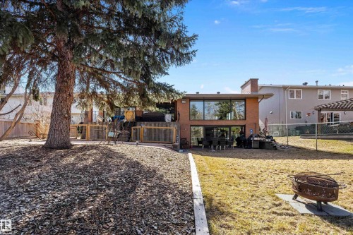 Expansive backyard featuring a large mature tree, mulched landscaping, and a substantial brick exterior with significant window space - 227 Westridge Road, Edmonton, AB - Outdoor