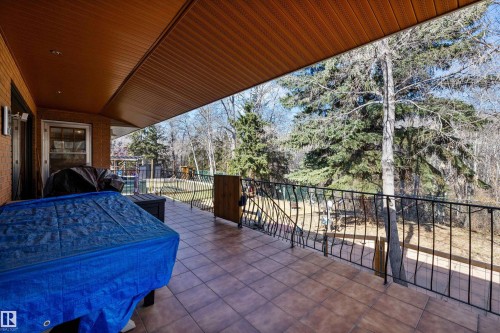 Covered outdoor patio with tile flooring and a black wrought iron railing - 227 Westridge Road, Edmonton, AB - Outdoor With Deck Patio Veranda With Exterior