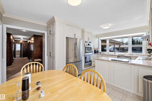 Spacious kitchen featuring white cabinetry, light-toned countertops, and a wide window above the sink - 227 Westridge Road, Edmonton, AB - Indoor