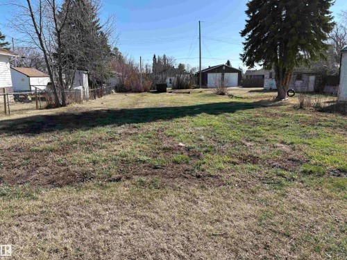 Spacious lot featuring established trees, partial fencing, and a clear expanse of ground - 4811 50 Ave, Holden, AB 