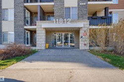 Modern building entrance featuring a stone facade and prominent address numbering - 