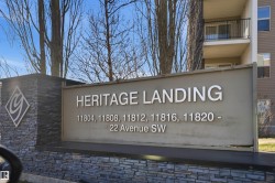 Monument sign featuring stacked stone base and pillar, building name, and address numbers - 