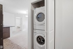 Dedicated laundry closet featuring a stacked white washer and dryer unit - 