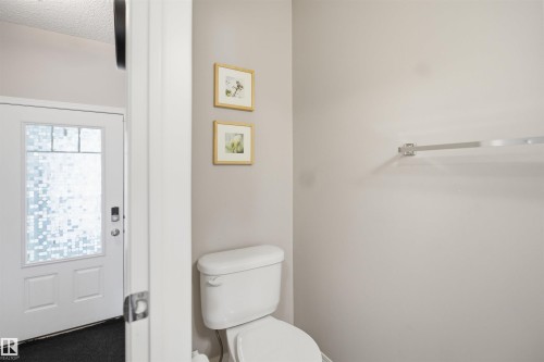 White interior door with frosted glass panels, featuring a black digital lock - 7323 24 Ave, Edmonton, AB - Indoor Photo Showing Bathroom