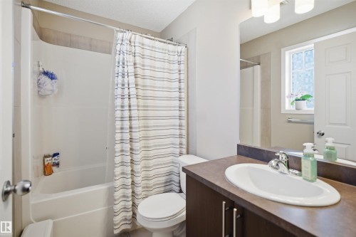 Bedroom featuring light gray wall paint, textured ceiling, light-colored carpet flooring, and a closet with a built-in shelving system - 7323 24 Ave, Edmonton, AB - Indoor Photo Showing Bedroom