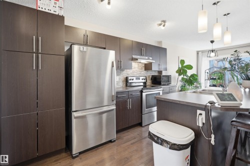 Entryway with light-toned wall finishes, tile flooring, and wood-finish flooring extending into the interior - 7323 24 Ave, Edmonton, AB - Indoor Photo Showing Other Room