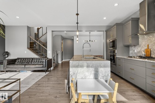 Spacious kitchen and living area featuring wood-finish flooring - 1737 Dumont Crescent, Edmonton, AB - Indoor Photo Showing Kitchen With Upgraded Kitchen