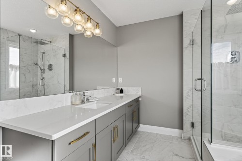 Contemporary bathroom featuring a spacious vanity with dual sinks, white countertop, and gold-tone hardware - 1737 Dumont Crescent, Edmonton, AB - Indoor Photo Showing Bathroom