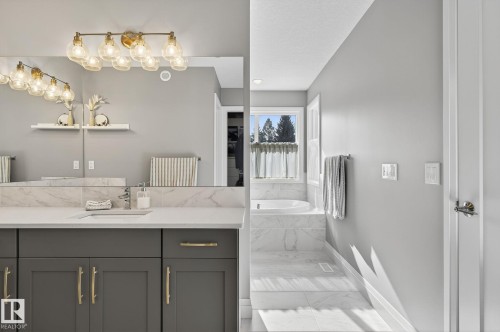 Bathroom vanity featuring a quartz countertop with an undermount sink and a polished chrome faucet - 1737 Dumont Crescent, Edmonton, AB - Indoor Photo Showing Bathroom