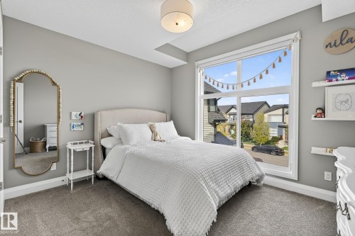 Bedroom featuring a large window, light gray painted walls, and gray carpeting - 1737 Dumont Crescent, Edmonton, AB - Indoor Photo Showing Bedroom