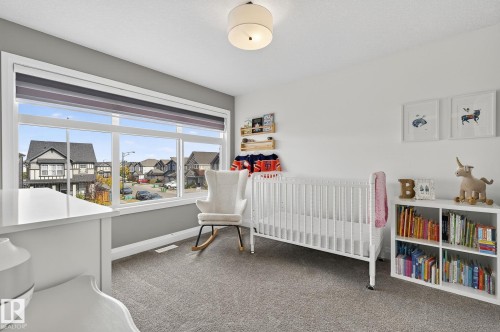 Room featuring a wide window with roller blinds, soft grey carpeting, and a flush mount ceiling light fixture - 1737 Dumont Crescent, Edmonton, AB - Indoor Photo Showing Bedroom