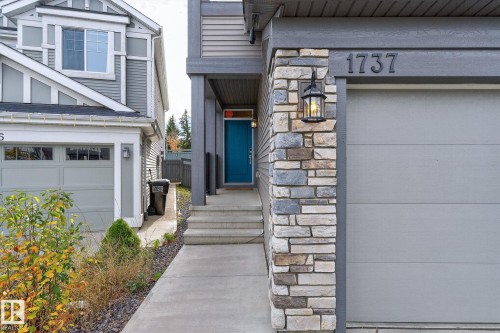 Contemporary exterior featuring stone accents, a teal entry door, and an attached garage - 1737 Dumont Crescent, Edmonton, AB - Outdoor With Facade