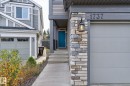 Contemporary exterior featuring stone accents, a teal entry door, and an attached garage - 1737 Dumont Crescent, Edmonton, AB  - Outdoor With Facade 
