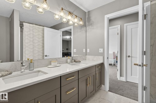 Dual vanity with integrated rectangular sinks, quartz countertops, and a full-width mirror - 1737 Dumont Crescent, Edmonton, AB - Indoor Photo Showing Bathroom