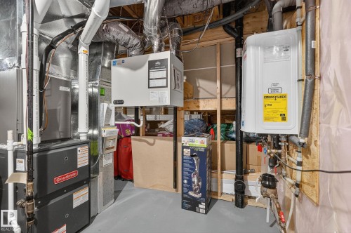 Utility area featuring a tankless water heater, Goodman furnace, and exposed ductwork - 1737 Dumont Crescent, Edmonton, AB - Indoor Photo Showing Basement