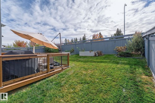 Expansive backyard featuring a wood deck with wood railing, a level lawn area, and perimeter fencing - 1737 Dumont Crescent, Edmonton, AB - Outdoor With Deck Patio Veranda