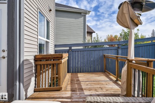 Expansive wooden deck featuring natural wood flooring and railings, complemented by a blue privacy fence - 1737 Dumont Crescent, Edmonton, AB - Outdoor With Deck Patio Veranda With Exterior