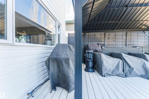 Exterior deck featuring a louvered pergola, privacy screens, and white horizontal siding - 847 Blacklock Way, Edmonton, AB - Outdoor With Deck Patio Veranda With Exterior