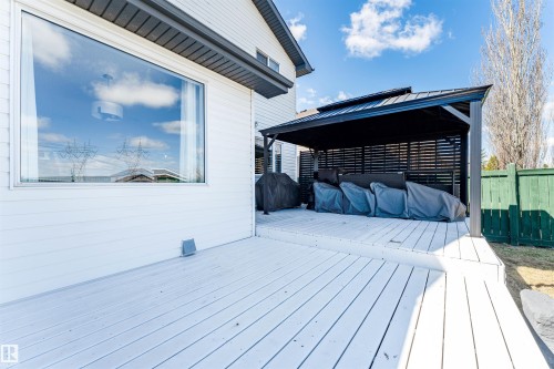 Expansive multi-level wood deck featuring a covered gazebo with slatted privacy screens, a wide picture window, and horizontal siding - 847 Blacklock Way, Edmonton, AB - Outdoor With Deck Patio Veranda With Exterior