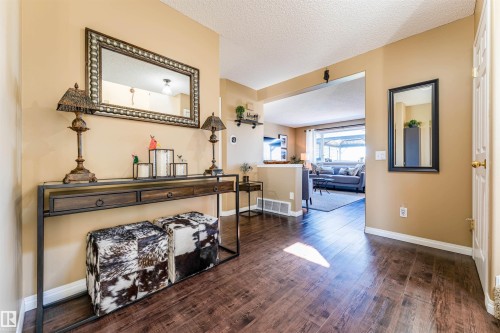 Wood-finish flooring extending from the entryway into the main living areas - 847 Blacklock Way, Edmonton, AB - Indoor Photo Showing Other Room
