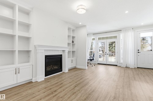 Your gas fireplace is surrounded by built in shelving and is wired for your TV. - 10430 143 Street, Edmonton, AB - Indoor Photo Showing Other Room With Fireplace