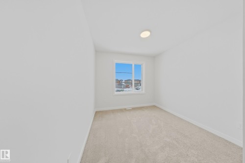 This room features neutral-toned carpet flooring, white walls, and a window providing natural light - 17 Trill Point(E), Spruce Grove, AB - Indoor Photo Showing Other Room