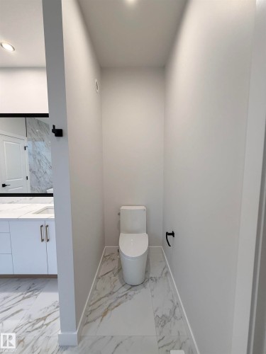 Powder room featuring a modern toilet, marble-style tiled floors, and recessed lighting - 17 Trill Point(E), Spruce Grove, AB - Indoor Photo Showing Bathroom