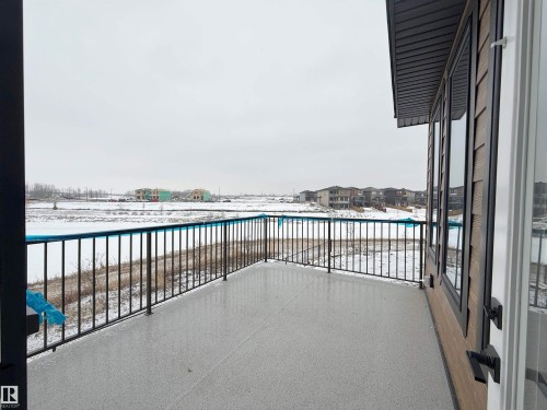 Enjoy views from the balcony, featuring a dark metal railing and a speckled grey floor, with a body of water visible in the distance - 17 Trill Point(E), Spruce Grove, AB - Outdoor
