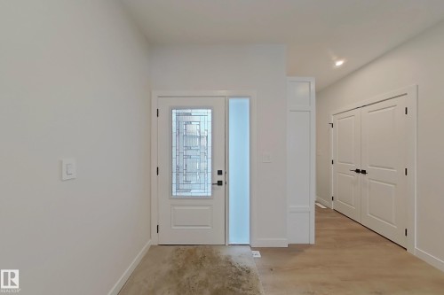 The property features an entryway with a light-colored door and a frosted glass sidelight - 17 Trill Point(E), Spruce Grove, AB - Indoor Photo Showing Other Room