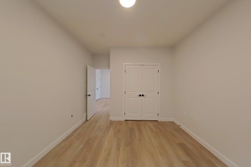 Interior room featuring light-toned walls, hardwood style flooring, and a ceiling light fixture - 17 Trill Point(E), Spruce Grove, AB - Indoor Photo Showing Other Room