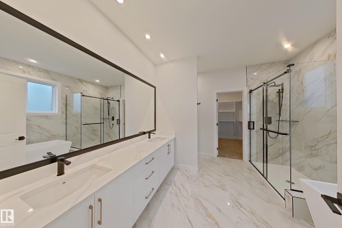 Elegant bathroom featuring a spacious vanity with dual sinks, a large mirror, and recessed lighting - 17 Trill Point(E), Spruce Grove, AB - Indoor