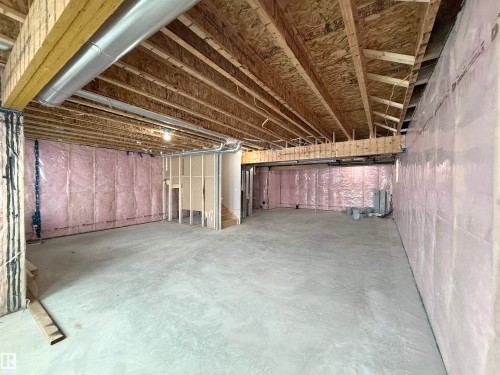 The property features an unfinished basement with exposed wooden joists and insulation on the perimeter walls, offering a substantial area for future customization - 17 Trill Point(E), Spruce Grove, AB - Indoor Photo Showing Basement