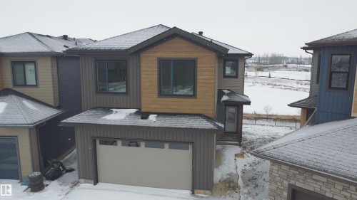 The property features a two-story exterior with a blend of horizontal siding and wood-look paneling, an attached garage, and a covered entry - 17 Trill Point(E), Spruce Grove, AB - Outdoor