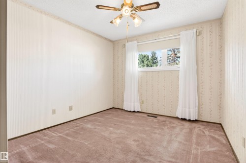 Neutral-toned wallpaper with a subtle pattern and a textured ceiling - 29 Bristow Crescent, Spruce Grove, AB - Indoor Photo Showing Other Room