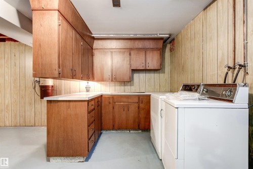 Utility area featuring extensive wood cabinetry, L-shaped countertop space, panel wall accents, and concrete flooring - 29 Bristow Crescent, Spruce Grove, AB - Indoor Photo Showing Laundry Room
