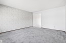 Spacious room with light gray patterned wallpaper, plush gray carpeting, and white painted walls - 29 Bristow Crescent, Spruce Grove, AB  - Indoor Photo Showing Other Room 