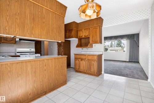 Kitchen with wood-finish cabinetry and a pass-through opening to a carpeted room - 29 Bristow Crescent, Spruce Grove, AB - Indoor Photo Showing Kitchen