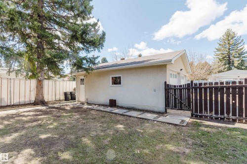 Detached garage with a light-colored stucco exterior, a single garage door, and a side entry door - 3752 114 Street, Edmonton, AB - Outdoor